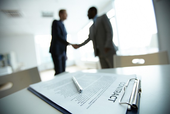 Image of business contract on background of two employees handsh570381
